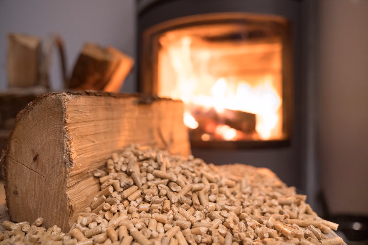 wood pellets and a split log in front of a burning pellet stove