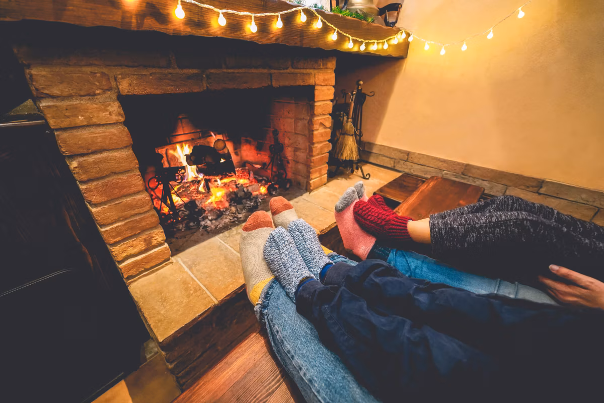 legs view of happy family lying down next fire place wearing warm wool socks - winter, holiday, love and cozy