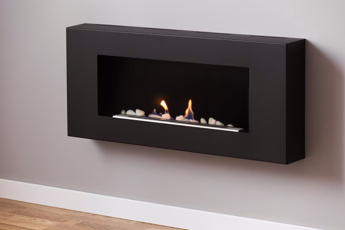 close-up on black fireplace on grey wall in simple living room interior real photo
