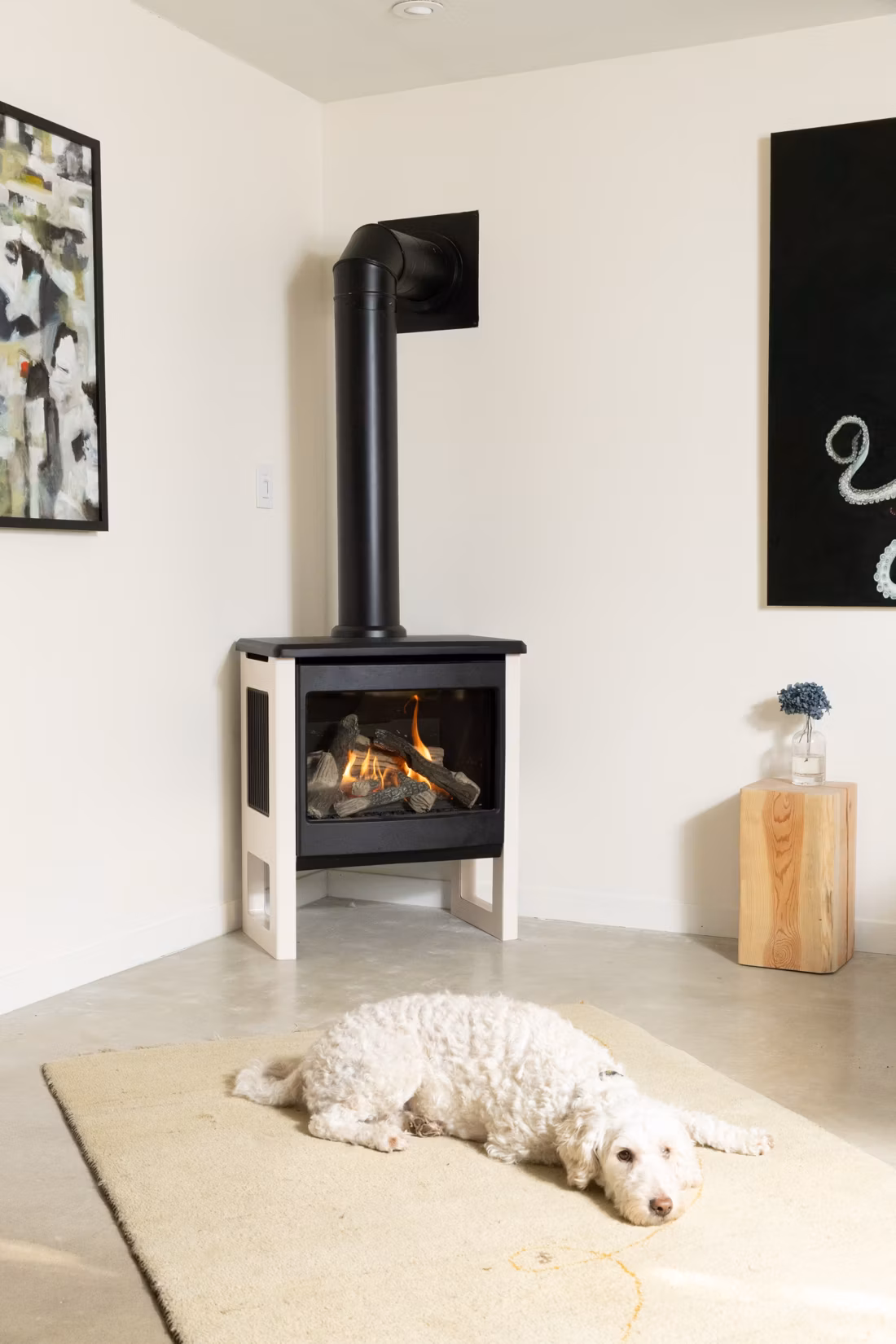 sleepy doodle dog stretched out below lit stove