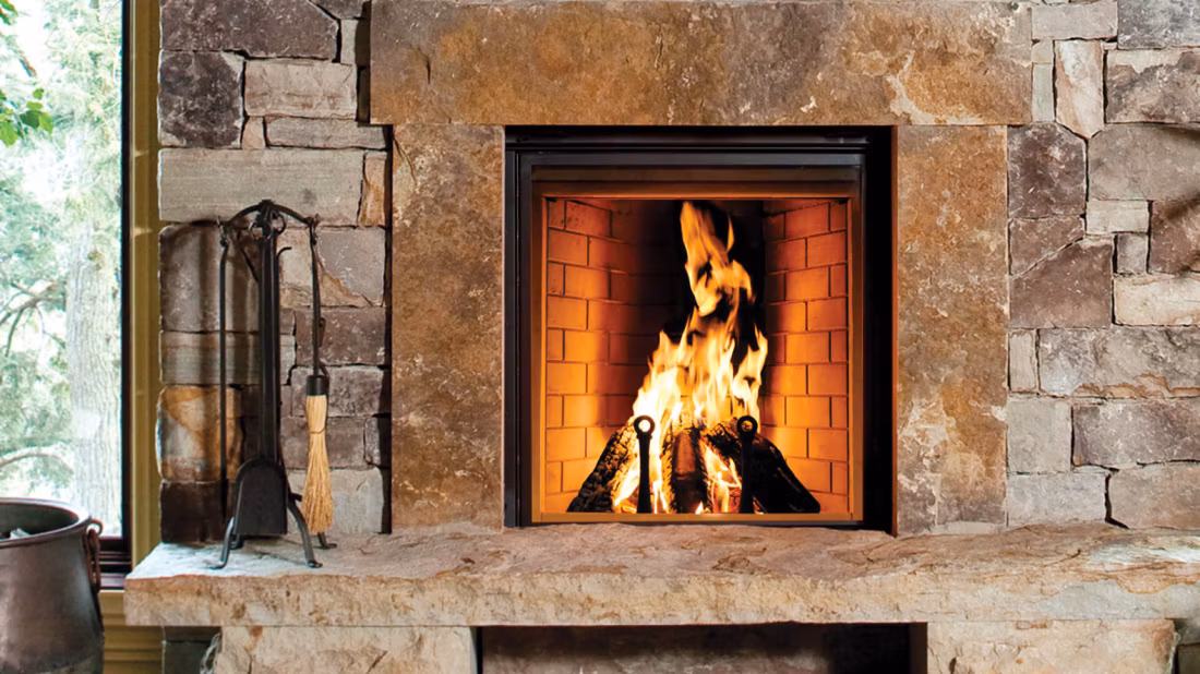 Rumford wood fireplace blazing in rustic stone hearth