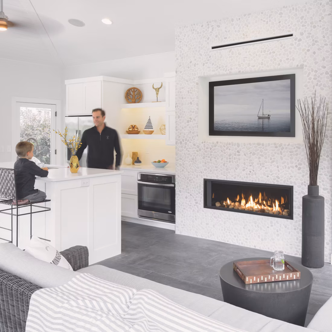 dad and son in white kitchen with linear fireplace