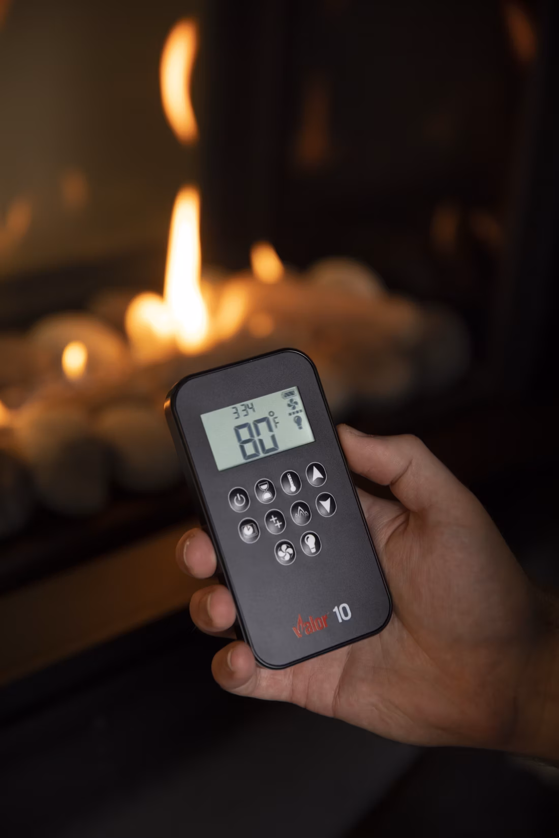closeup of remote control in hand, fire background