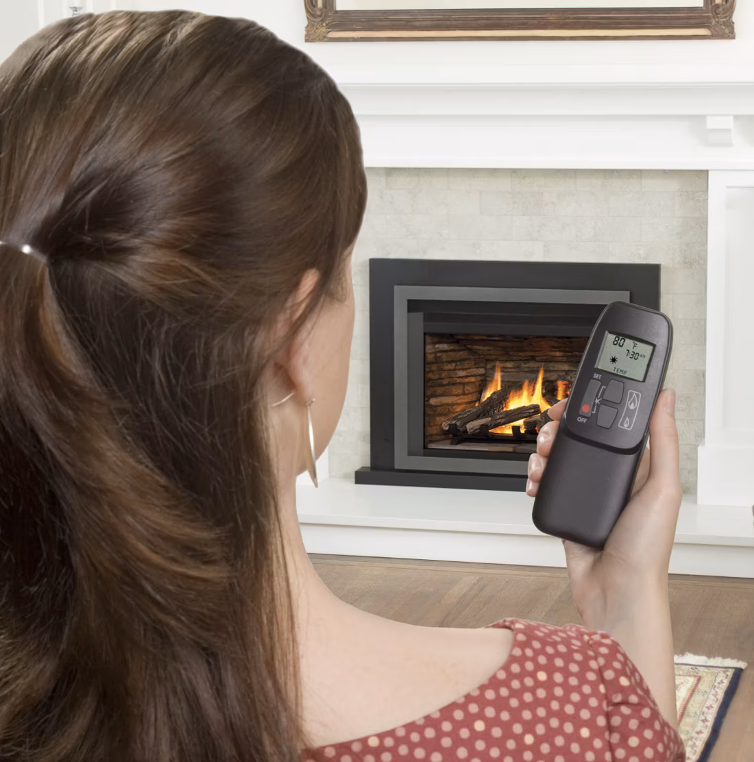 woman seen from behind operating fireplace remote