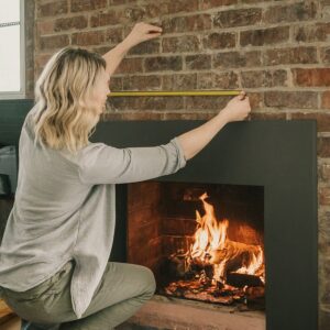 ![Person measuring an open brick fireplace with a tape measure for proper dimensions](https://findmyfireplace.com/wp-content/uploads/2025/05/shutterstock_2628466097-2-e1747413124359-1024x372.jpg)